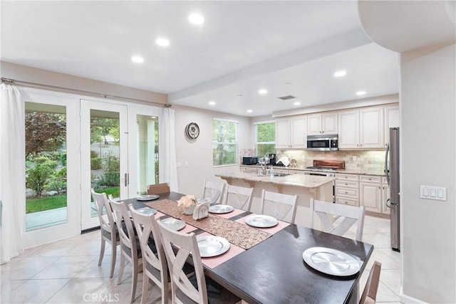 tiled dining space featuring a wealth of natural light and sink