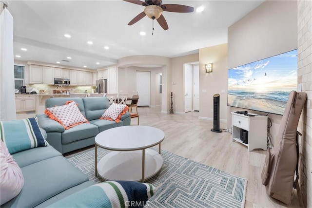 living room with ceiling fan and light wood-type flooring