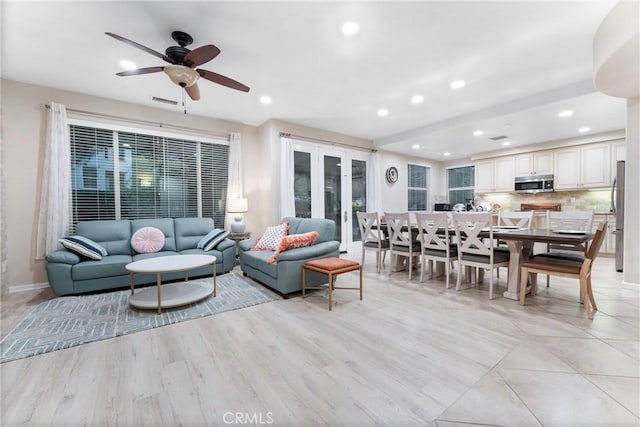 living room with light hardwood / wood-style flooring and ceiling fan