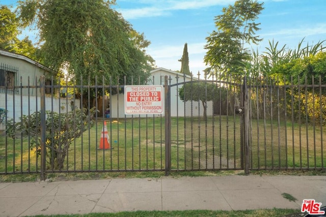 view of gate with a lawn