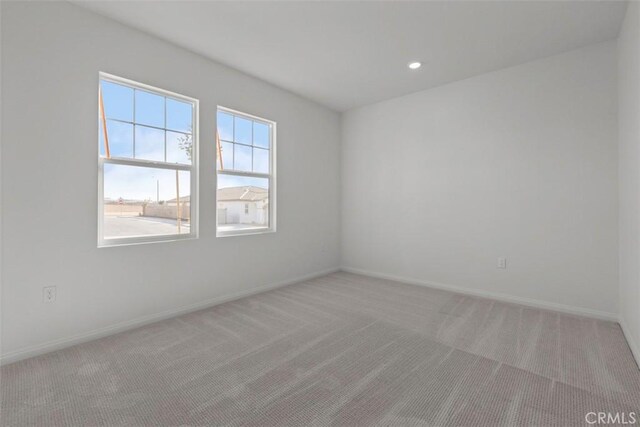 unfurnished room featuring light colored carpet