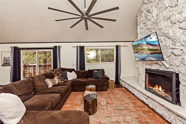 living room featuring vaulted ceiling, a fireplace, and ceiling fan