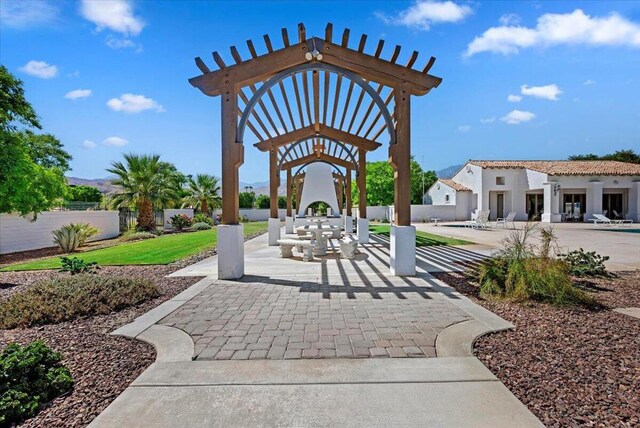 view of home's community featuring a patio area, a lawn, and a pergola