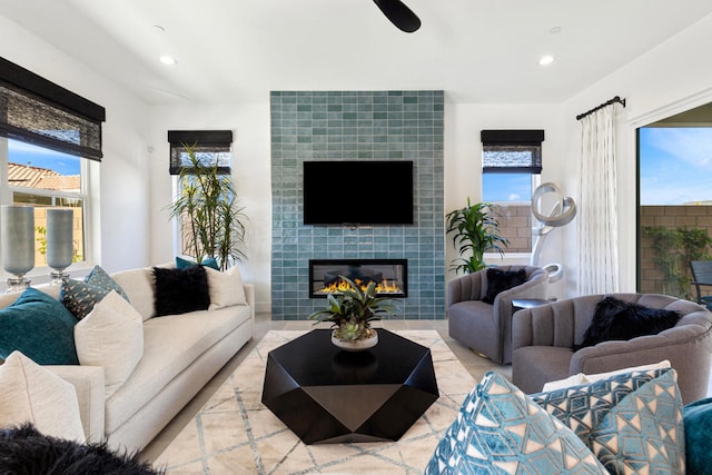 living room with a healthy amount of sunlight and a tile fireplace