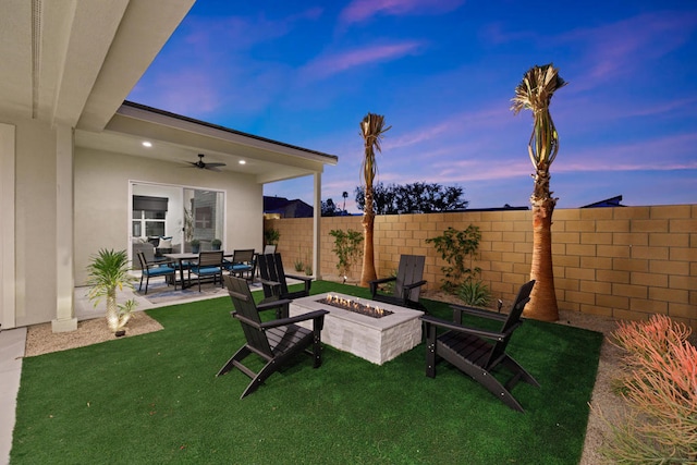 yard at dusk with a patio, a fire pit, and ceiling fan