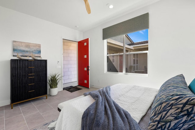 bedroom with ceiling fan, a skylight, and tile patterned flooring