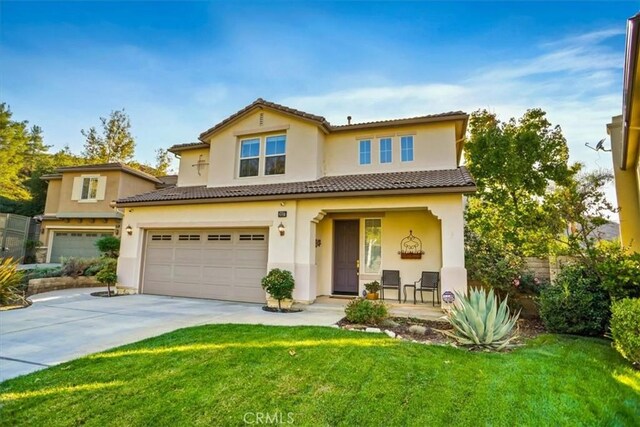 mediterranean / spanish-style home with a front lawn and a garage