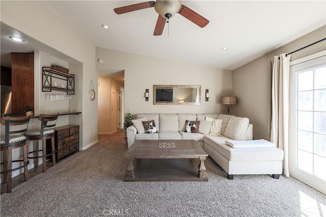 carpeted living room with ceiling fan, plenty of natural light, and lofted ceiling