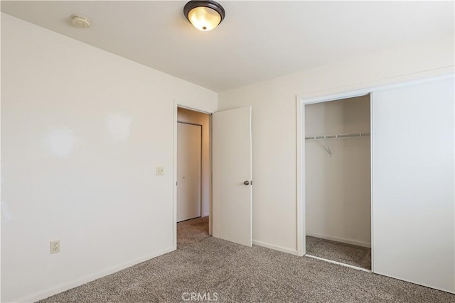 unfurnished bedroom featuring carpet floors and a closet