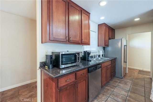 kitchen featuring sink, dark stone counters, and appliances with stainless steel finishes