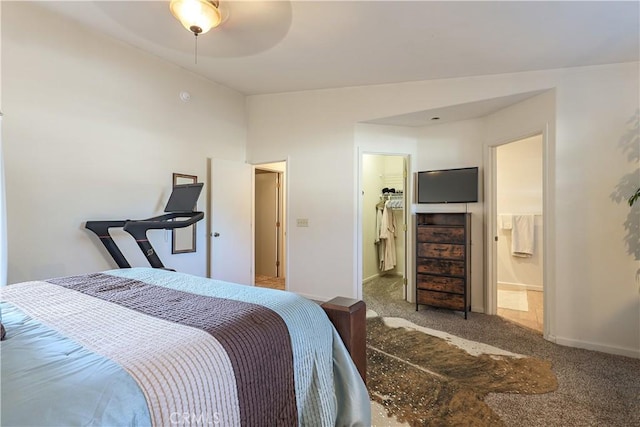 carpeted bedroom with ensuite bath, a spacious closet, a closet, and ceiling fan