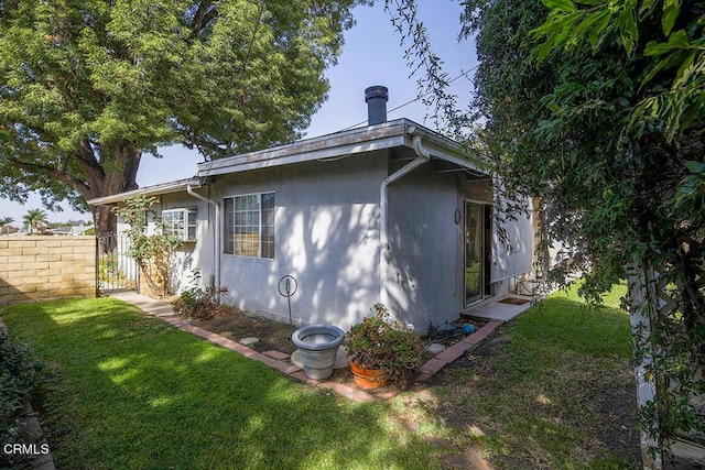 view of side of home with a yard