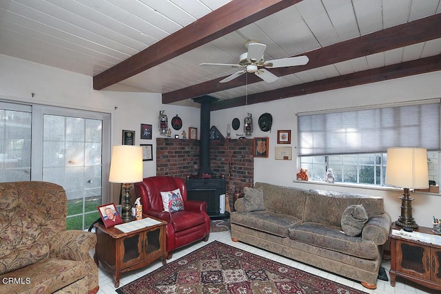 tiled living room with ceiling fan, beam ceiling, a wood stove, and wooden ceiling