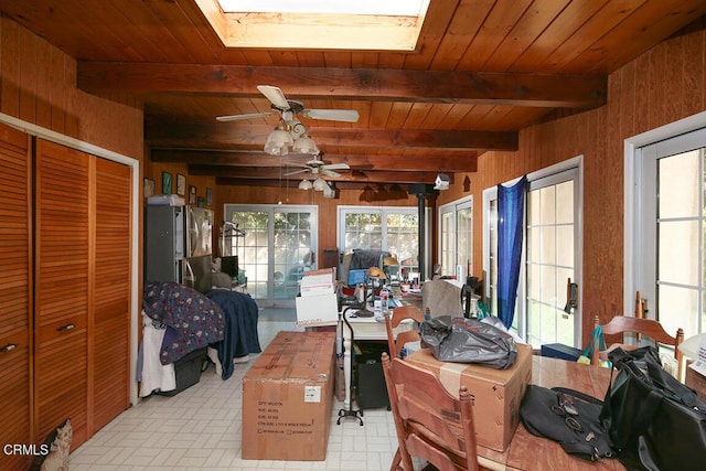 sunroom featuring beam ceiling, a skylight, ceiling fan, and wood ceiling