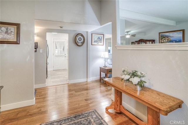 corridor with vaulted ceiling with beams and light hardwood / wood-style floors