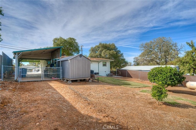 exterior space with a carport, cooling unit, and a storage unit