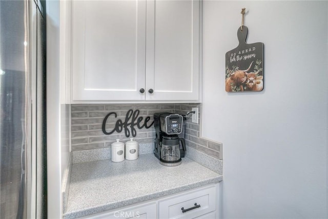 interior details featuring decorative backsplash and stainless steel refrigerator