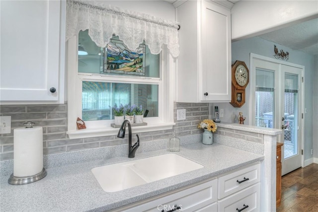 kitchen with a healthy amount of sunlight, sink, and white cabinets