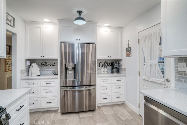 kitchen with white cabinetry, beverage cooler, stainless steel fridge, backsplash, and hanging light fixtures