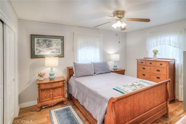 bedroom with ceiling fan, a closet, and light hardwood / wood-style flooring