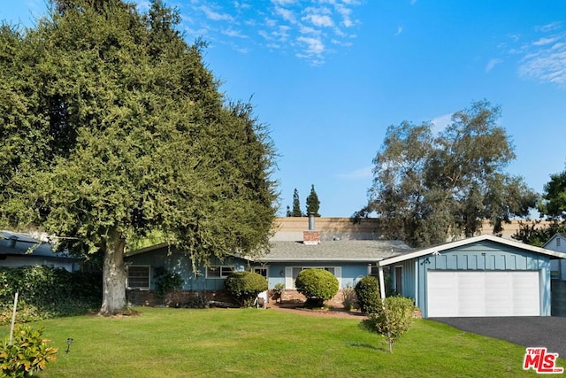 ranch-style home featuring a garage and a front lawn