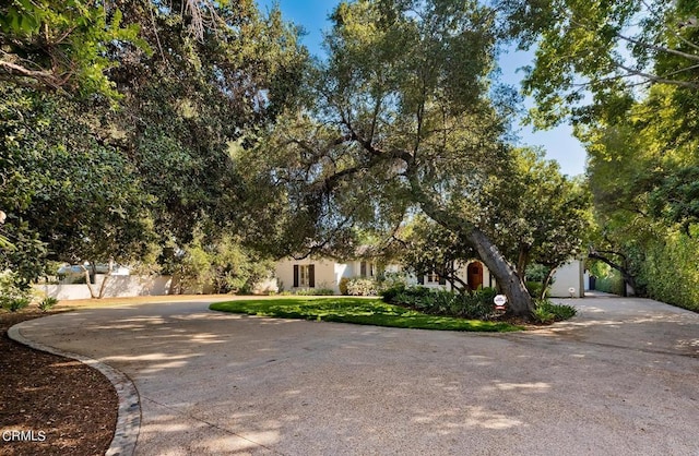 view of property hidden behind natural elements featuring a garage