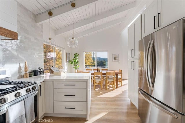 kitchen featuring pendant lighting, white cabinetry, appliances with stainless steel finishes, beamed ceiling, and light hardwood / wood-style floors