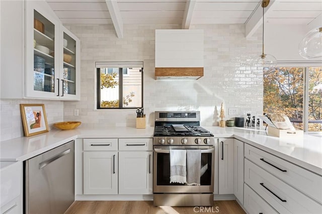 kitchen featuring wood ceiling, white cabinetry, hanging light fixtures, stainless steel appliances, and beamed ceiling