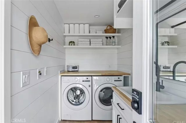 laundry area featuring washer and dryer and wood walls