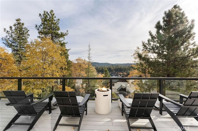 wooden terrace featuring an outdoor living space with a fire pit