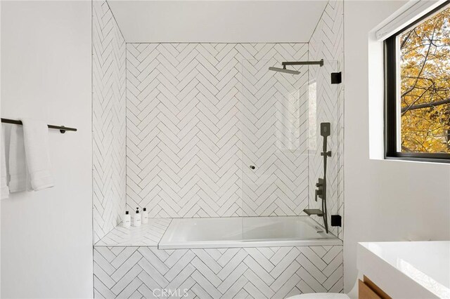 bathroom featuring plenty of natural light and tiled shower / bath combo