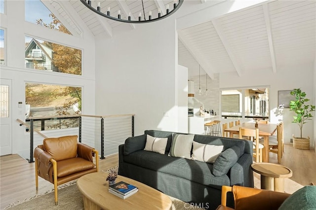 living room featuring wood-type flooring, high vaulted ceiling, and beam ceiling