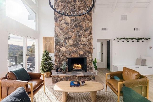 living room with wood ceiling, hardwood / wood-style floors, beam ceiling, a high ceiling, and a fireplace