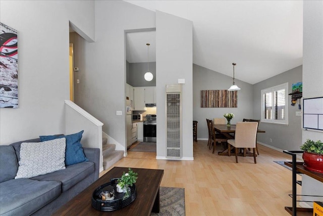 living room featuring high vaulted ceiling and light wood-type flooring