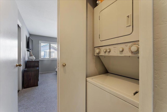 clothes washing area with stacked washer / drying machine and light colored carpet