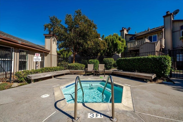 view of swimming pool with a hot tub