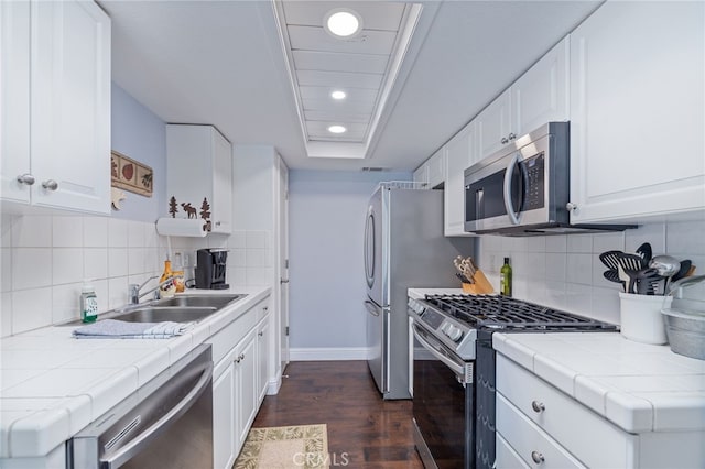 kitchen with white cabinets, stainless steel appliances, and dark hardwood / wood-style floors