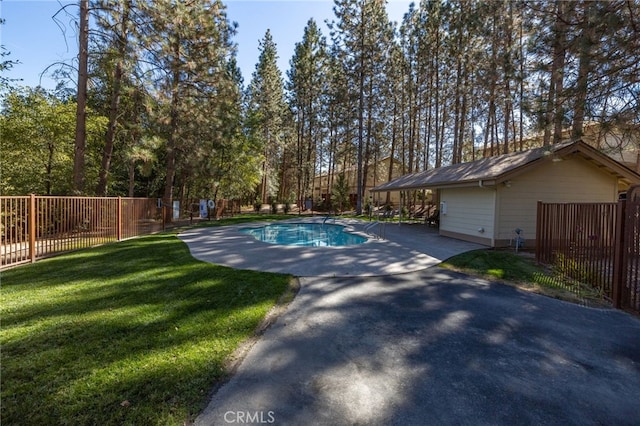 view of swimming pool featuring a yard and a patio area