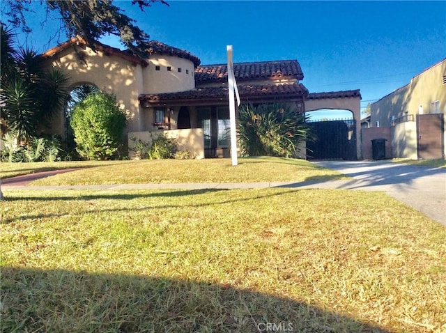 mediterranean / spanish home featuring a front lawn