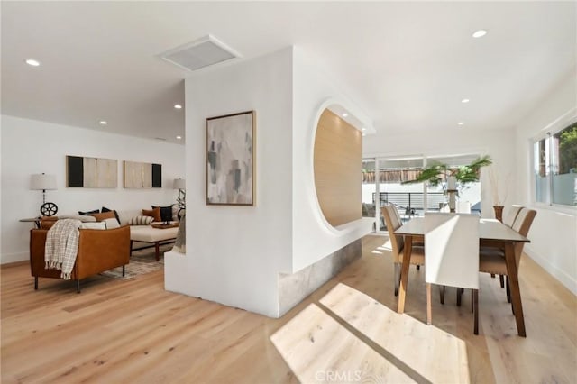 dining area featuring plenty of natural light and light hardwood / wood-style flooring