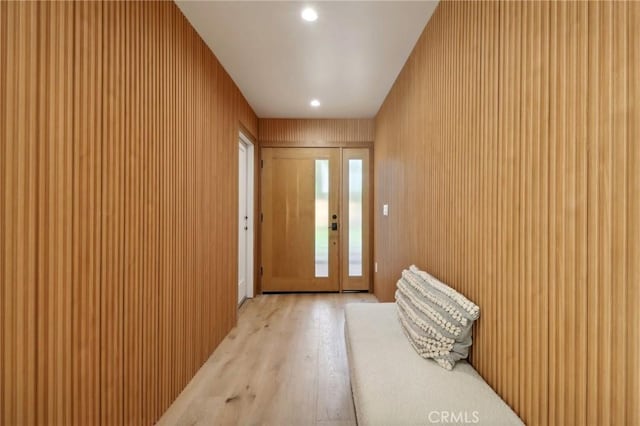 doorway to outside featuring wooden walls and light wood-type flooring