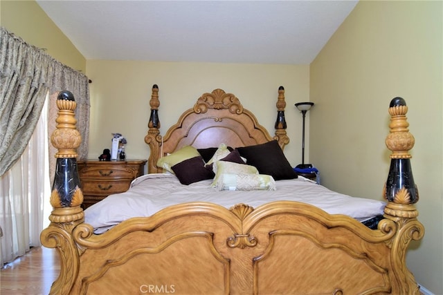 bedroom featuring light hardwood / wood-style floors and lofted ceiling