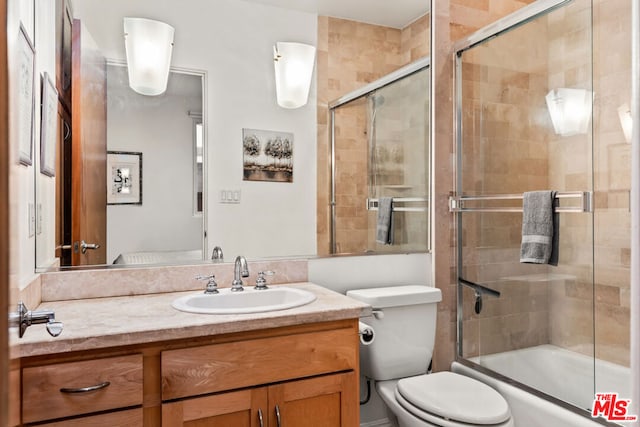 full bathroom with vanity, toilet, and combined bath / shower with glass door