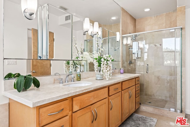 bathroom featuring tile patterned floors, a shower with door, and vanity