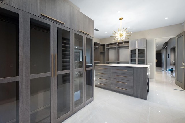 walk in closet featuring a notable chandelier and light tile patterned floors