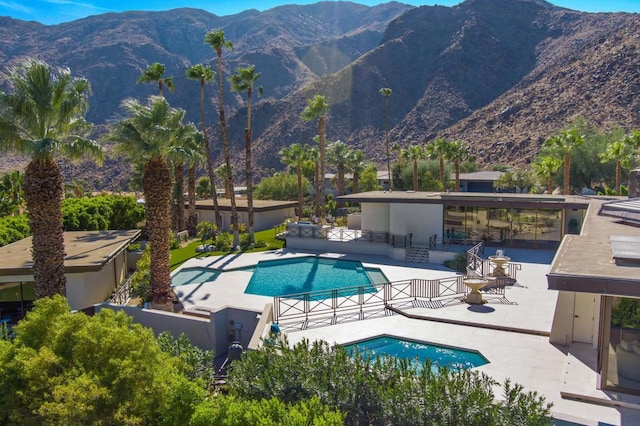 view of swimming pool with a mountain view and a patio area