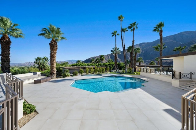 view of swimming pool featuring an outdoor living space, a mountain view, and a patio