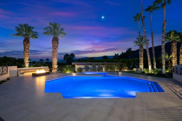 pool at dusk with a patio area