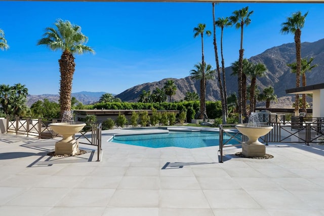 view of swimming pool featuring a patio and a mountain view