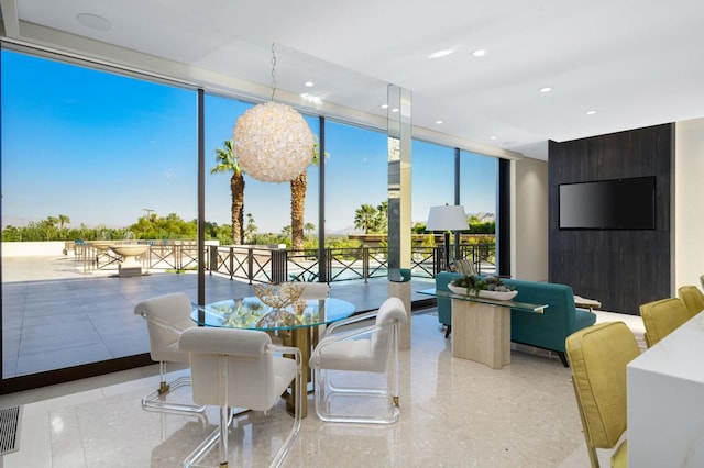 dining room with a notable chandelier and a wall of windows